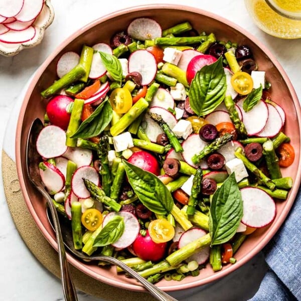 Asparagus Salad recipe served in a bowl with lemon vinaigrette on the side from top view