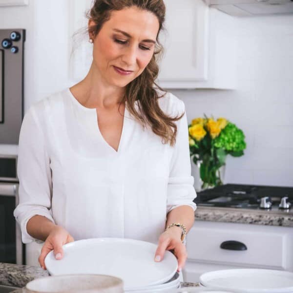 Aysegul organizing dishes on the counter in the kitchen.