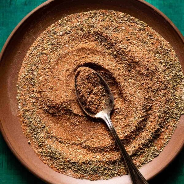 Homemade blackening seasoning on a plate with a spoon in the middle.