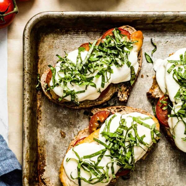 Caprese Chicken Sandwich on a sheet pan garnished with basil