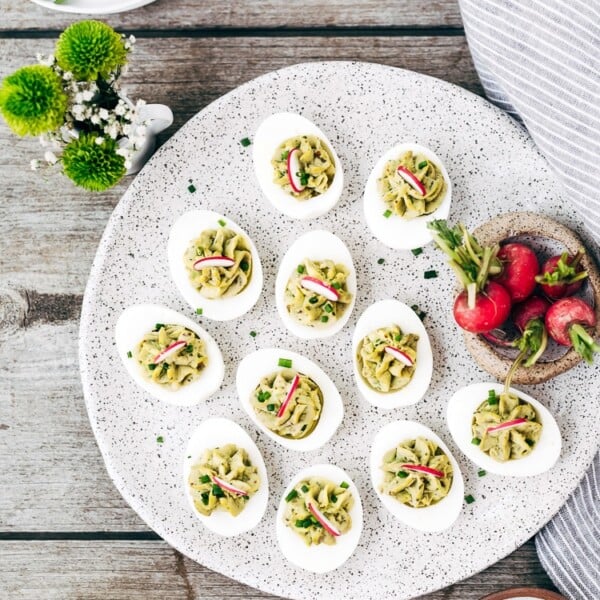 A plate filled with deviled eggs with mayo are photographed from the top view.