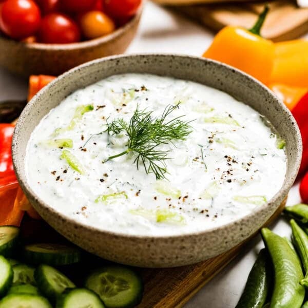Tzatziki sauce in a bowl garnished with dill.