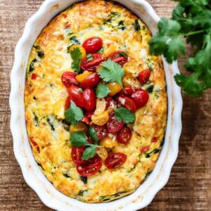 Egg casserole topped off with tomatoes from the top view.