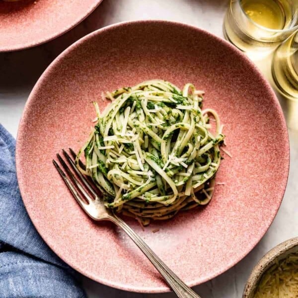 A pasta dish with spinach sauce in a bowl from the top view.