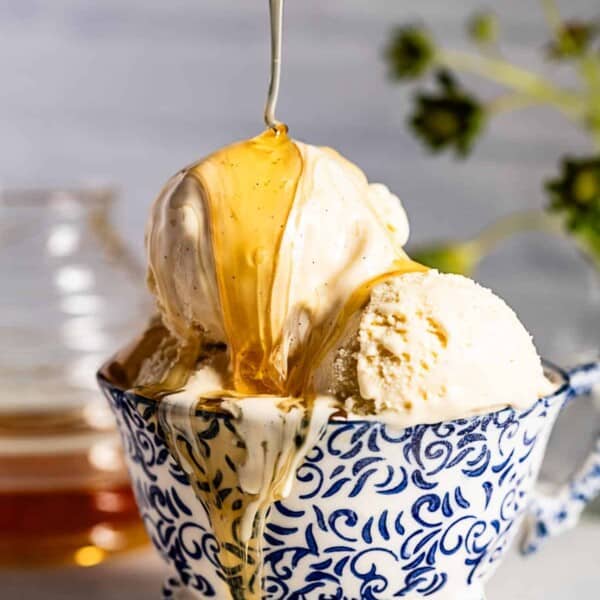 Honey ice cream being drizzled with honey from the front view.
