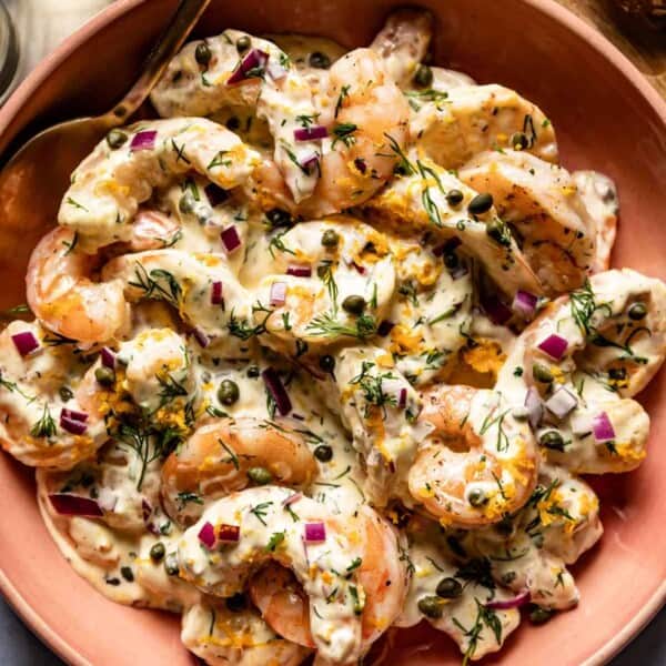 Ina Garten roasted shrimp salad in a bowl with a spoon on the side.