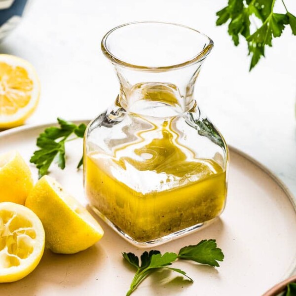 Lemon vinaigrette placed in a glass jar on a plate