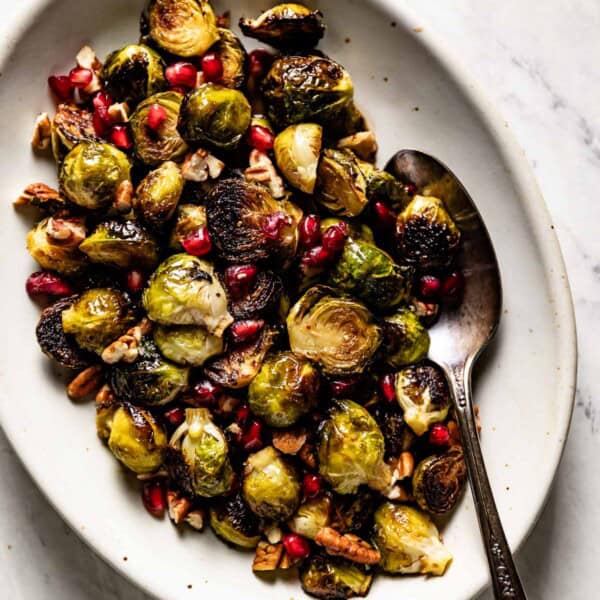 Maple balsamic Brussels sprouts on a plate with a spoon on the side.