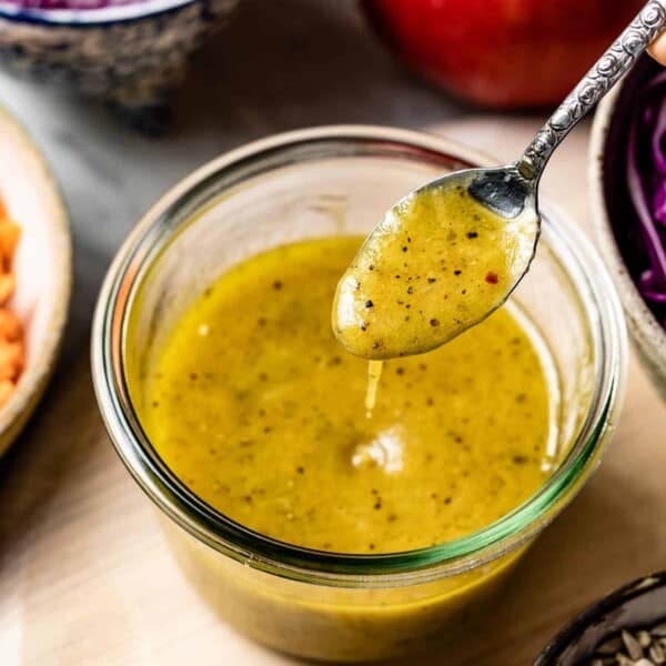 Maple Dijon Dressing in a spoon drizzling