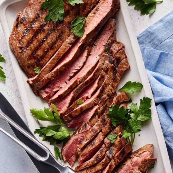 Marinated flank steak sliced on a plate.