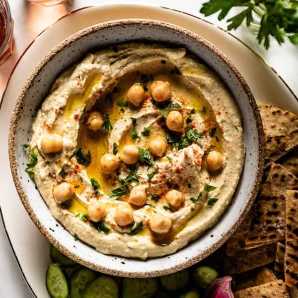 Mediterranean hummus in a bowl with veggies on the side.