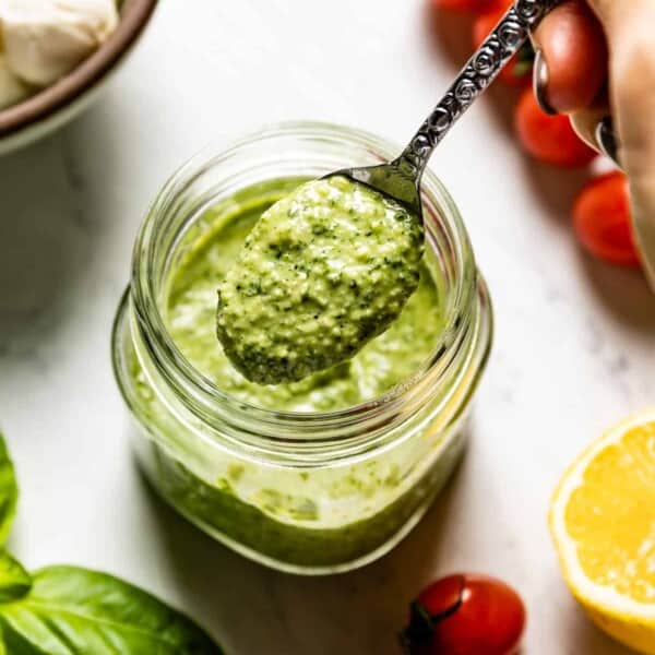 Pesto Vinaigrette served with a spoon by a person.