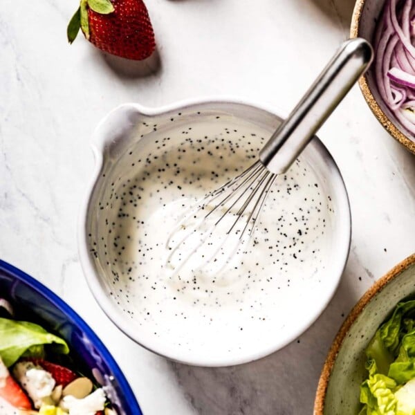 Creamy Poppy Seed Dressing in a bowl with a whisk