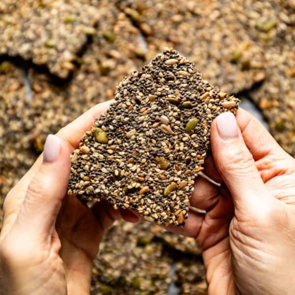 Person holding a seed cracker in her hand.