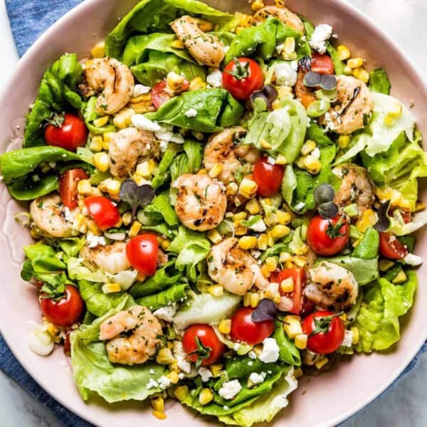 Shrimp Corn Salad in a pink bowl with wine on the side