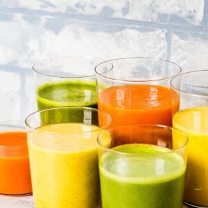 Colorful smoothies in clear glasses.