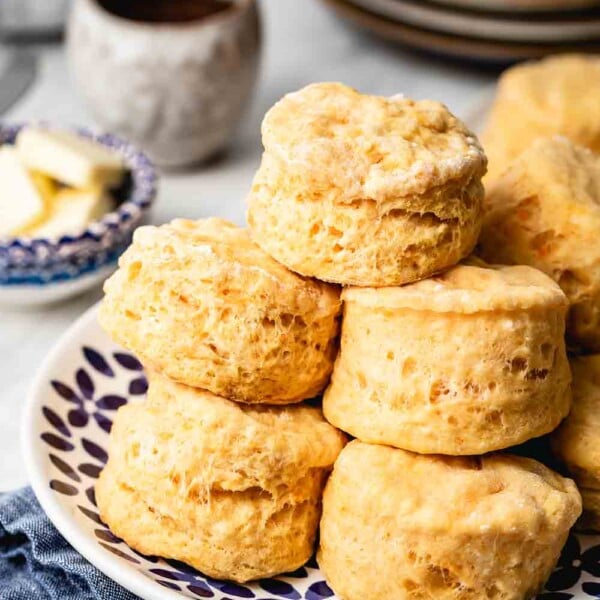 Sweet Potato Biscuits Recipe - Biscuits are placed on a plate on top of each other with butter in the background