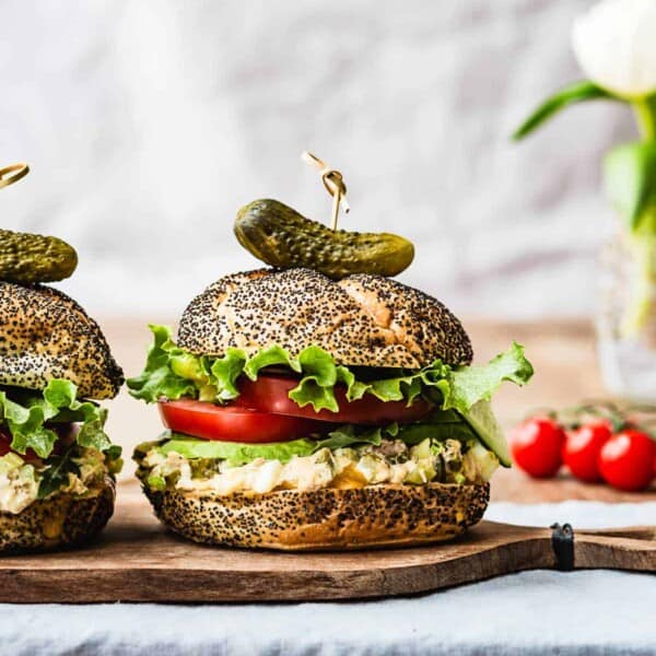 Tuna Melt Sandwich from the front view with tomatoes in the background.