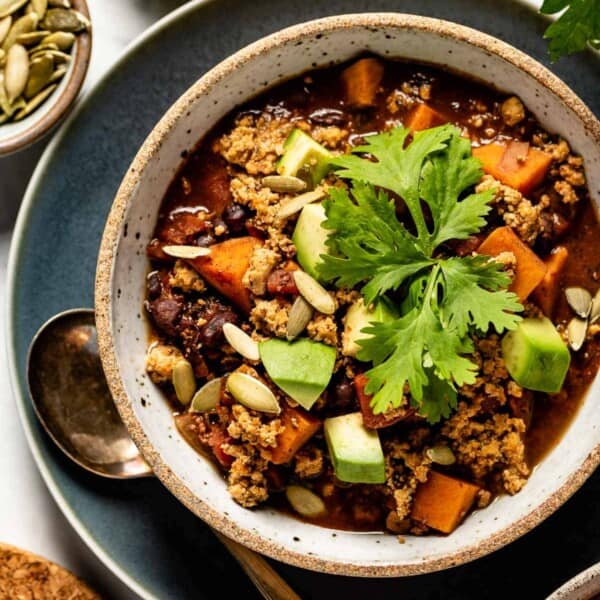 Vegan chocolate chili in a bowl with a spoon on the side